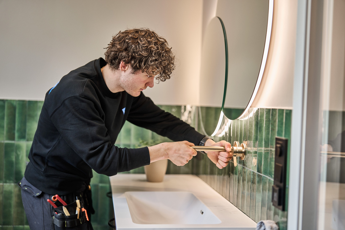 Rørlegger fra Engelsviken Rør fester et veggmontert servantarmatur.